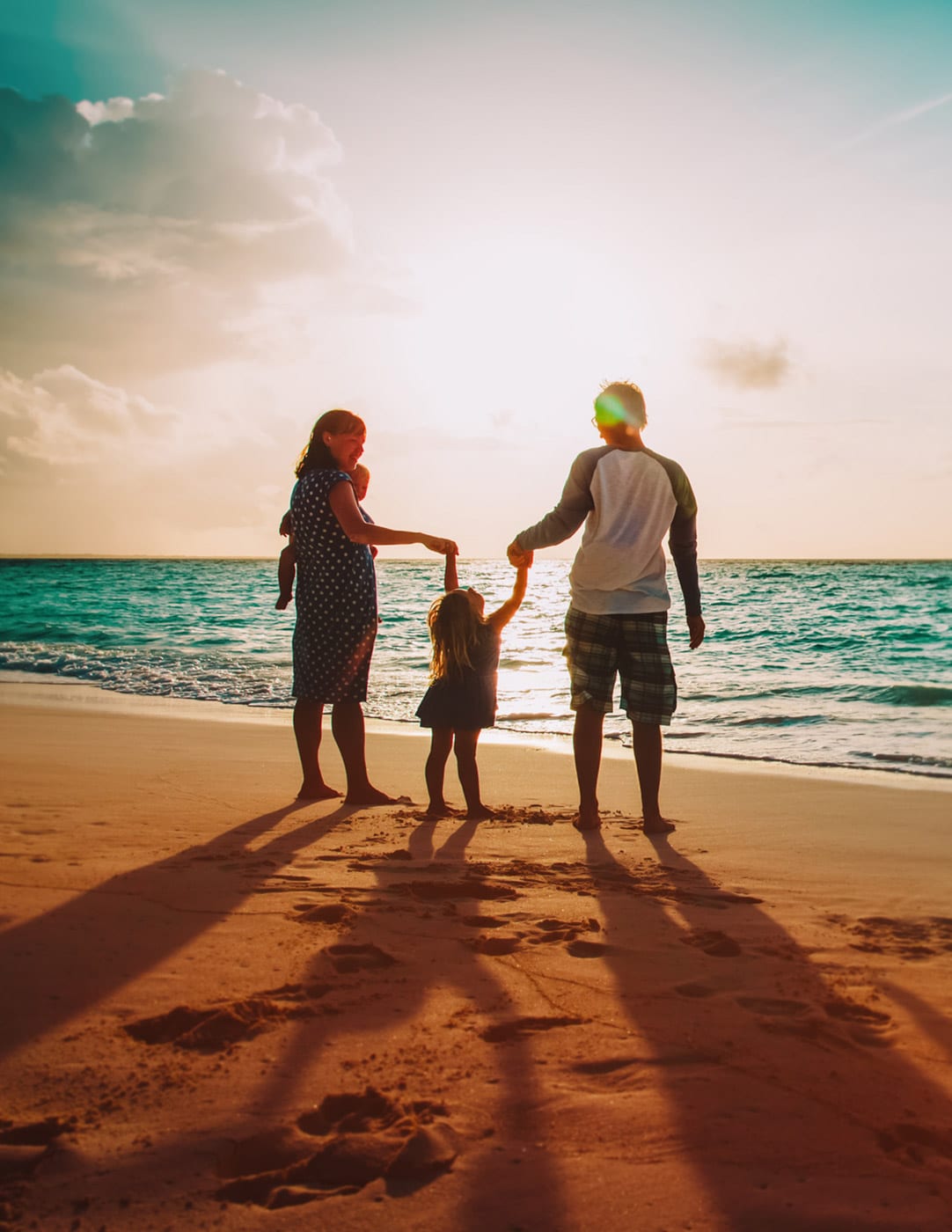 parents on beach from back with young kid